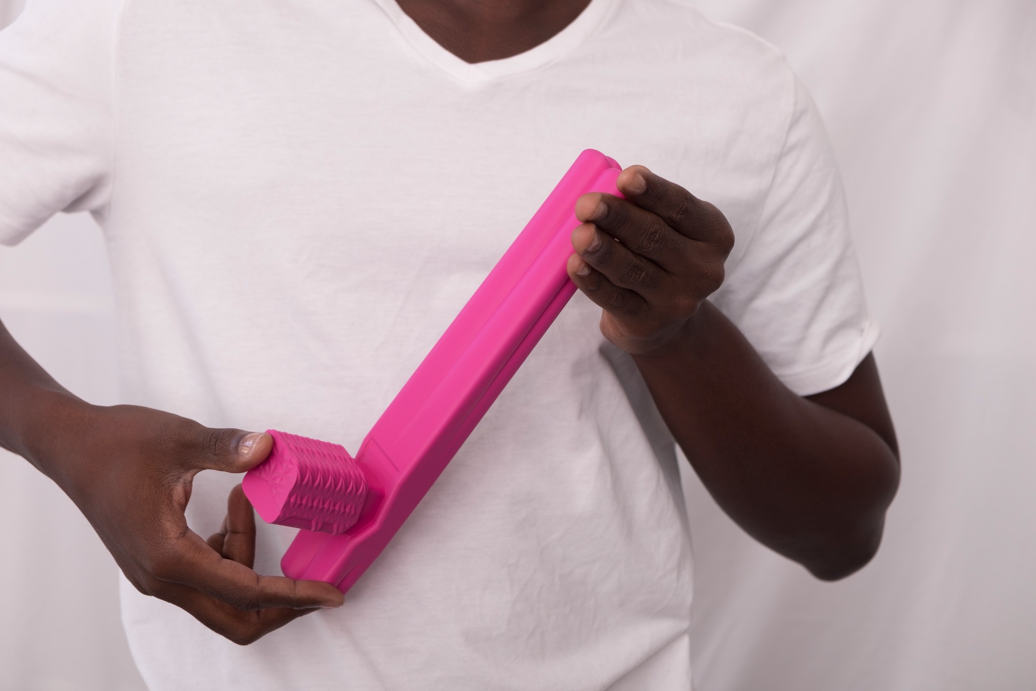 A person holds two pink Hudson Yards sculptures