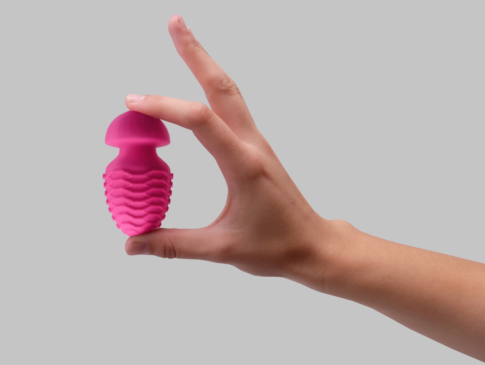 The pink Vessel sculpture held in a hand